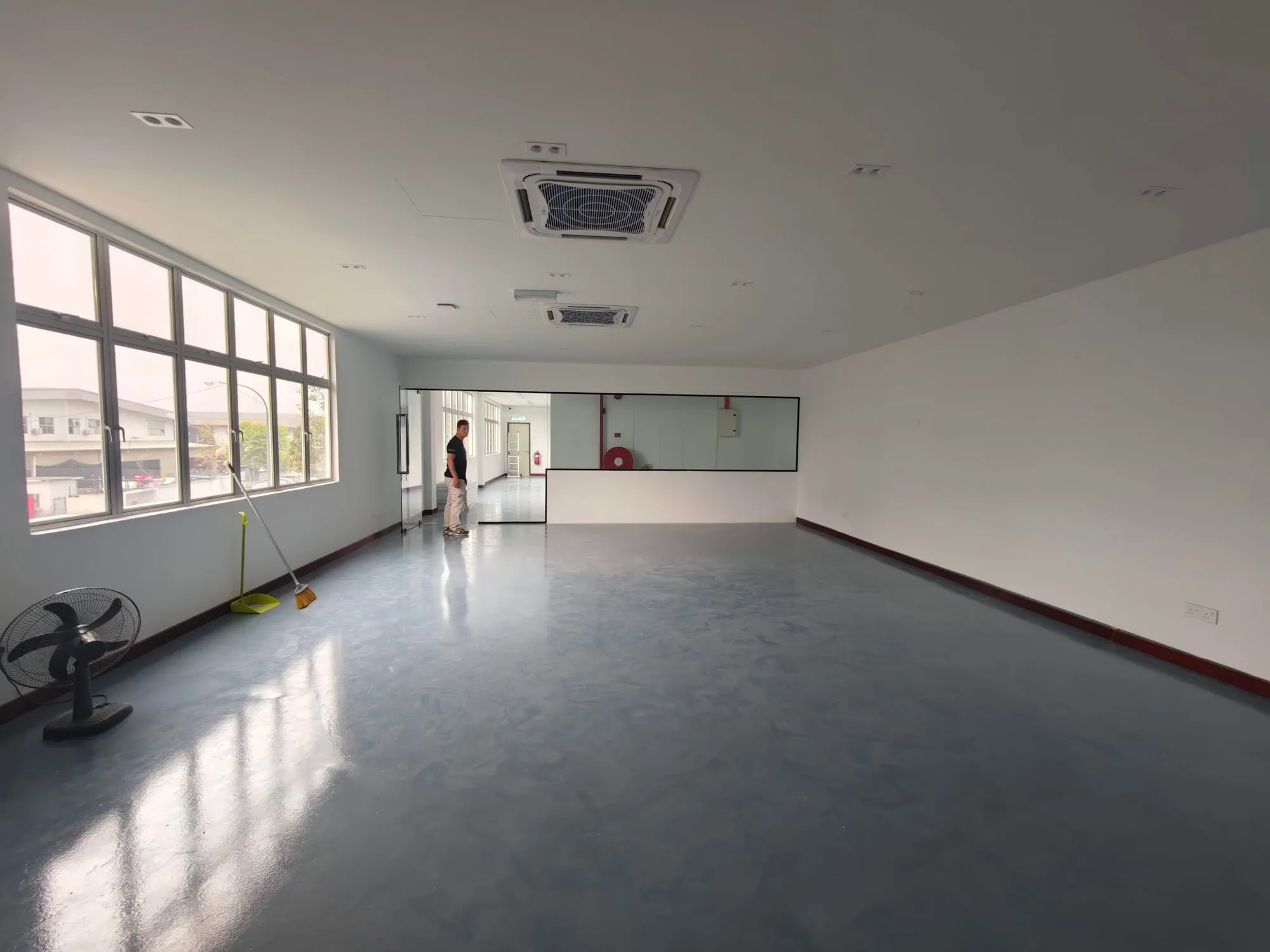Bright open-plan office floor inside a completed factory, with ceiling air conditioning